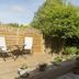 Bramlies in Dorchester garden patio with deck chairs, potted flowers, and wooden fencing
