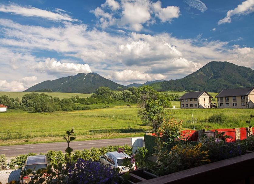 Penzion Drak in Liptovský Mikuláš with mountain views, green fields, and a roadside terrace