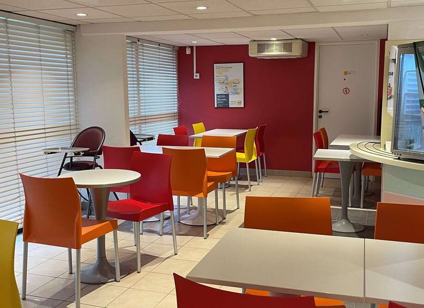 Premiere Classe Metz Nord - Semecourt breakfast room with colorful chairs and tables in Semécourt