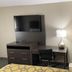 Baymont by Wyndham Topeka guest room with TV, desk, chair, lamp and kitchenette nook