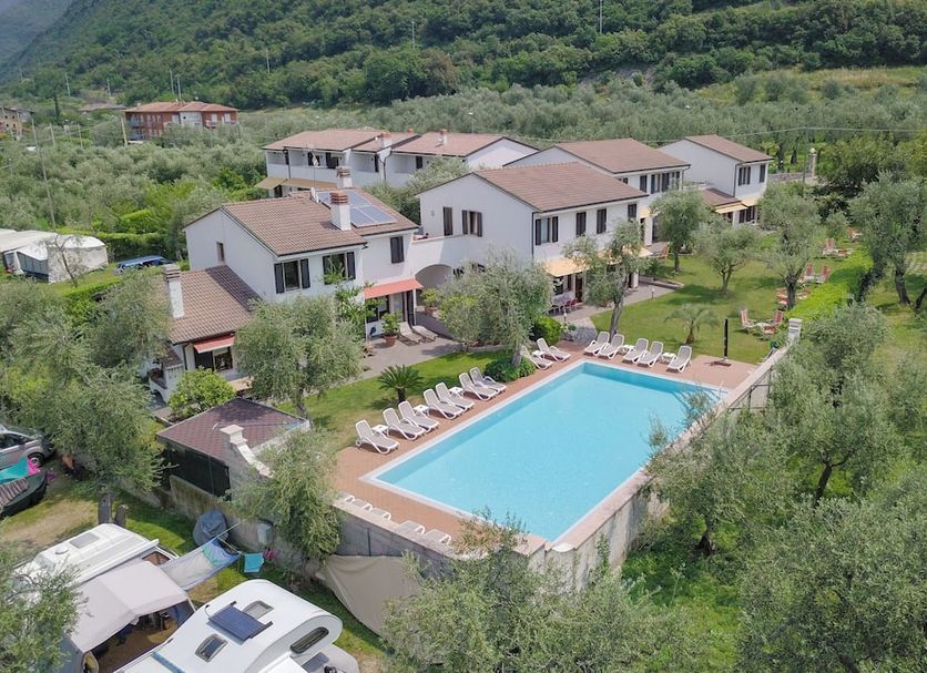 Residence Alesi in Malcesine with outdoor pool, sun loungers, and hillside garden setting