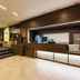 Hotel Villa Delle Rose - Malpensa lobby in Oleggio with wood reception desk, red chair and seating area