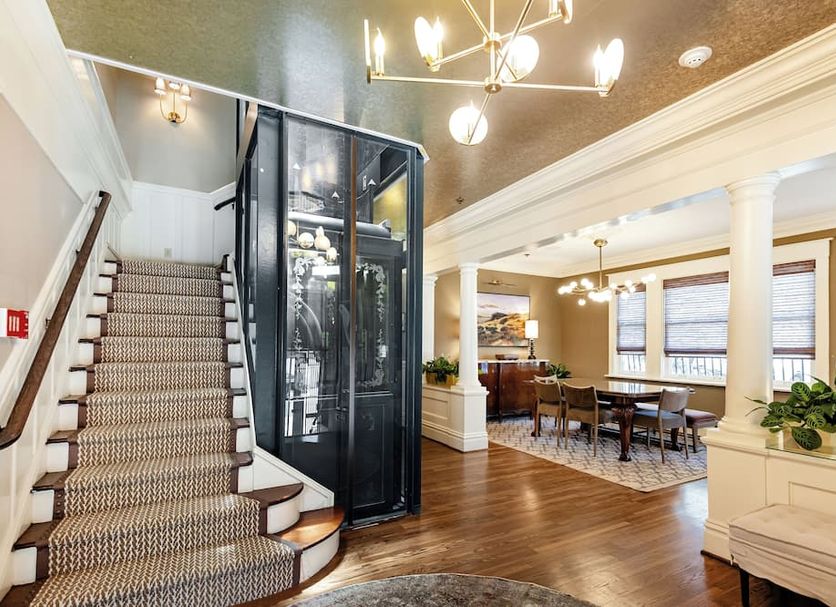 Nob Hill Inn in San Francisco lobby with staircase, glass elevator, and dining area