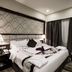 Al Muhaidb Residence Al Ahsa in Hofuf: elegant hotel room with king bed, lamps, and lounge chair