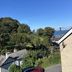 Newberry Beach Lodge, Ilfracombe: sea view over trees and rooftops with parked cars and blue sky