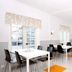 Airport Motel & Apartment in Gardermoen breakfast room with white tables, black chairs, and orange floor mats
