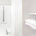 Super 8 by Wyndham Beaver Dam bathroom with white shower, grab bar, and folded towels