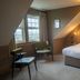 The Cottage In the Wood, Malvern: cozy attic hotel room with double bed, chairs, and window seating
