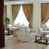 Mawlamyine Strand Hotel lounge with sofas, coffee tables and large windows in Mawlamyine