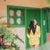 Hotel Cielo y Selva, San Cristóbal de las Casas: woman in yellow outfit by green doorway and potted plants