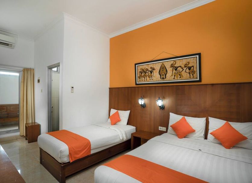 Hotel Poncowinatan - Tugu in Yogyakarta: twin room with orange accent wall and beds