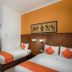 Hotel Poncowinatan - Tugu in Yogyakarta: twin room with orange accent wall and beds