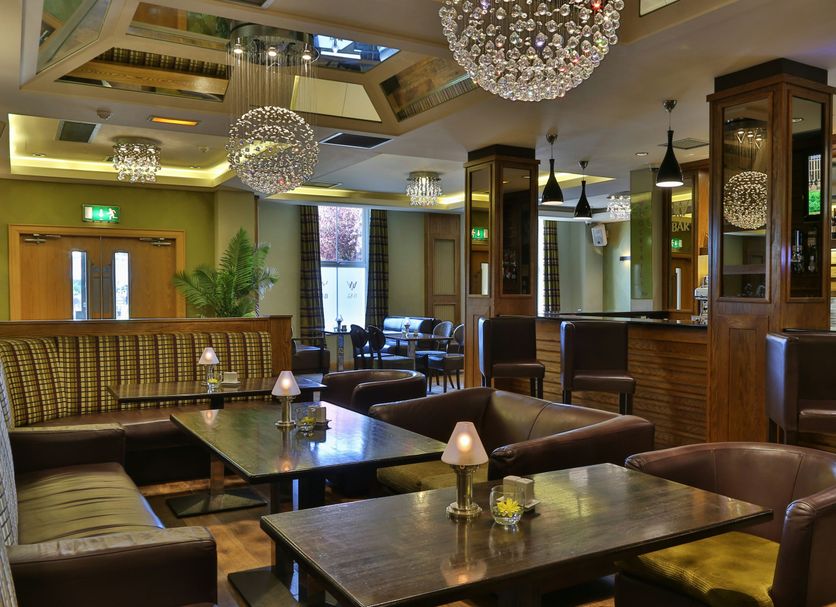 Westville Hotel Enniskillen lounge with leather chairs, wooden tables and decorative pendant lights
