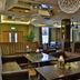 Westville Hotel Enniskillen lounge with leather chairs, wooden tables and decorative pendant lights