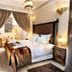 Riad Belle Epoque Marrakech guest room with four-poster bed, draped curtains, and seating area