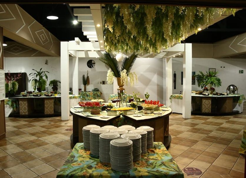 Hotel Mato Grosso Águas Quentes buffet dining area with round food tables and hanging greenery in Agua Quente