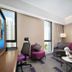 Hampton By Hilton Beijing Wangjing room with sofa, desk chair, city view and wall art in Beijing