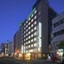 Hotel Shimbashi Sambankan in Tokyo, exterior at dusk on a city street with lit windows