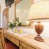 Grand Hotel Des Alpes in San Martino di Castrozza: cozy room with wooden desk, lamp, TV, and balcony doors