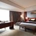 Juneyao International Hotel Yichang guest room with king bed, desk, armchair and floor-to-ceiling curtains