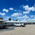 Snowy Mountain Inn in Saratoga with gravel parking lot, parked pickup trucks, and blue sky