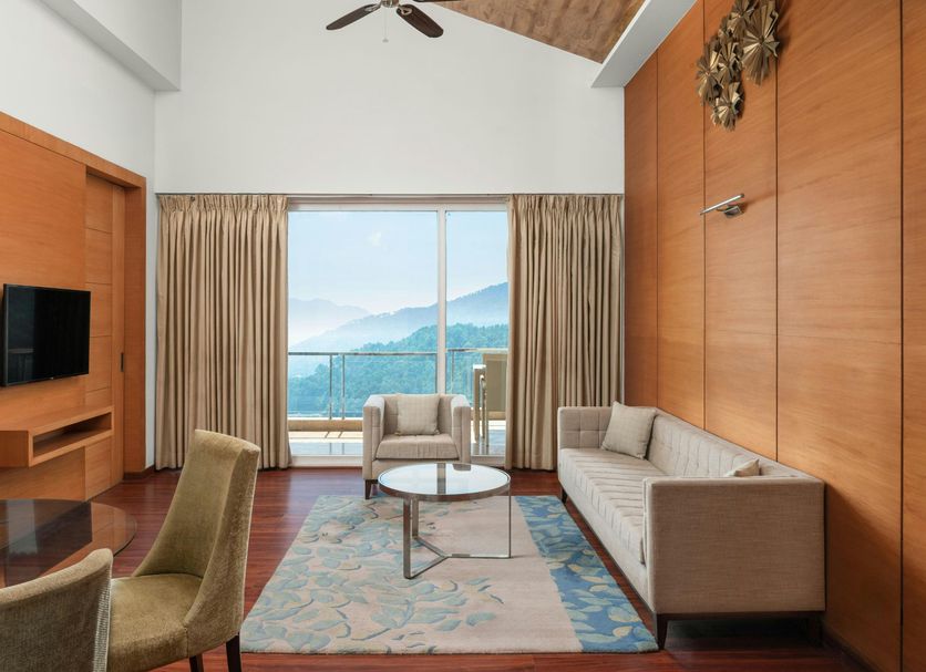 The Fern Surya Resort Dharampur, Kasauli Hills suite with mountain-view balcony and seating area