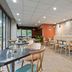 Appart'City Confort Lille Grand Palais dining area with tables, booth seating, and large windows in Lille