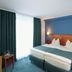 Hotel & Restaurant Eurohof Duisburg guest room with double bed, blue walls, and seating area