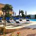 Residence Corte Dei Venti in Budoni with outdoor pool, loungers and umbrellas beside a brick terrace