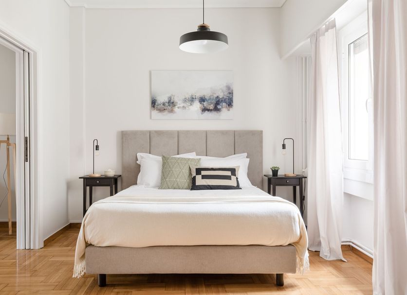 Central Cozy Apartments in Plaka by Upst Athens bedroom with queen bed, wood floors and window light