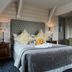 The Coed-Y-Mwstwr Hotel in Bridgend bedroom with a double bed, bedside lamps, desk and chair