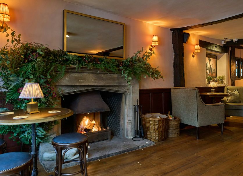 The White Horse in Dorking: cozy lounge with lit fireplace, wood floors, and armchairs