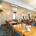 Hotel Rheinischer Hof Bad Soden dining room with wooden tables, blue chairs, chandeliers and mirrored walls