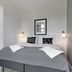 Kragsbjerggaard in Odense guest room with double bed, gray bedding and sofa seating area