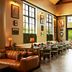 Berkshires Untold in Lenox dining room with leather sofa, long table, and large windows overlooking greenery