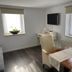 Weserlounge Hotel Garni in Hessisch Oldendorf: bright room with dining table, chairs, wall TV and windows
