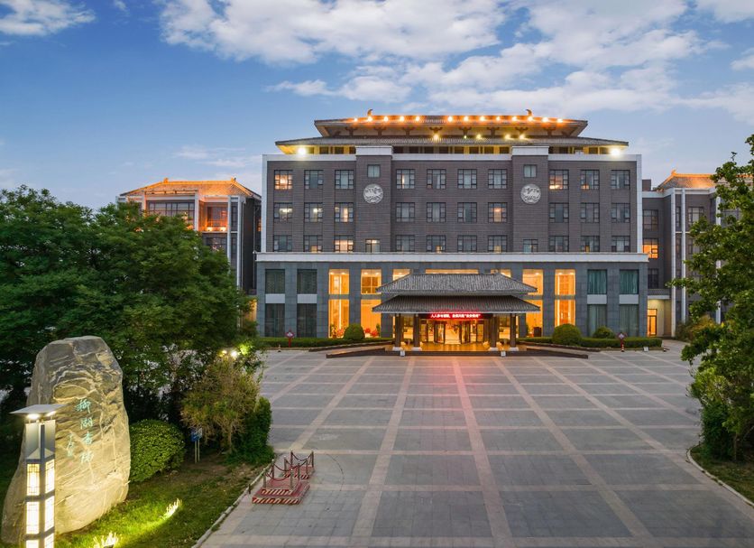 Liuhu Hotel (Hot Spring Garden Hotel) in Dezhou, exterior with illuminated entrance and plaza