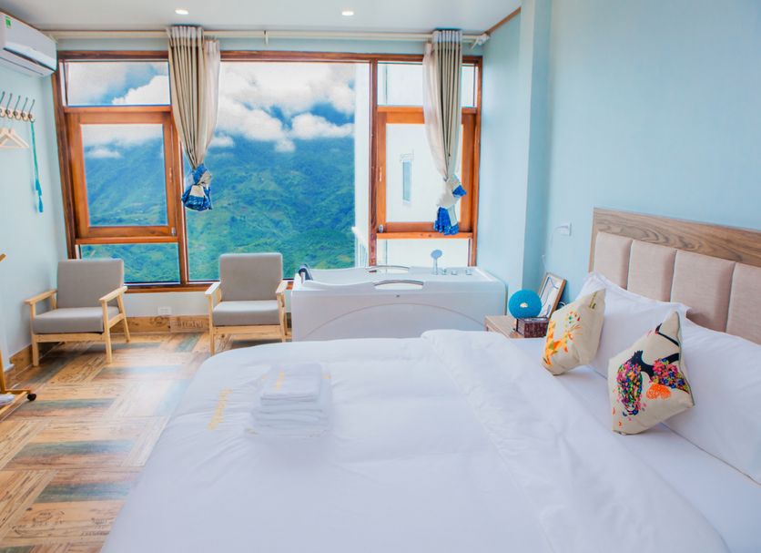 The Grand Blue Hotel Sa Pa room with mountain-view windows and white bed