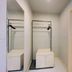 Century Star Urumqi Changjiang Road Hotel closet area with hanging rods beside a bathroom in Ürümqi