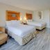 Capital O Duncanville Tx room with two beds, wood-look floors, desk and chair in Duncanville
