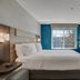 Holiday Inn Express & Suites Portland-Jantzen Beach hotel room with king bed, desk, TV and waterfront window view