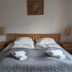 Engimyri Lodge bedroom in Akureyri with twin bed, bedside tables, lamps and folded towels