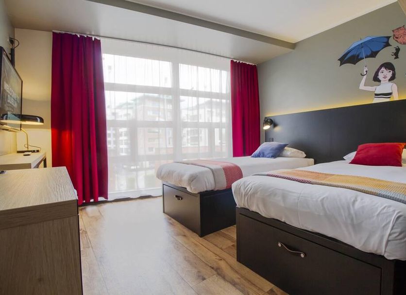 Generator Dublin in Dublin, twin room with two single beds and large window with red curtains