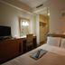 Central Hotel Fukuoka guest room in Fukuoka with bed, desk, mirror and warm bedside lamp