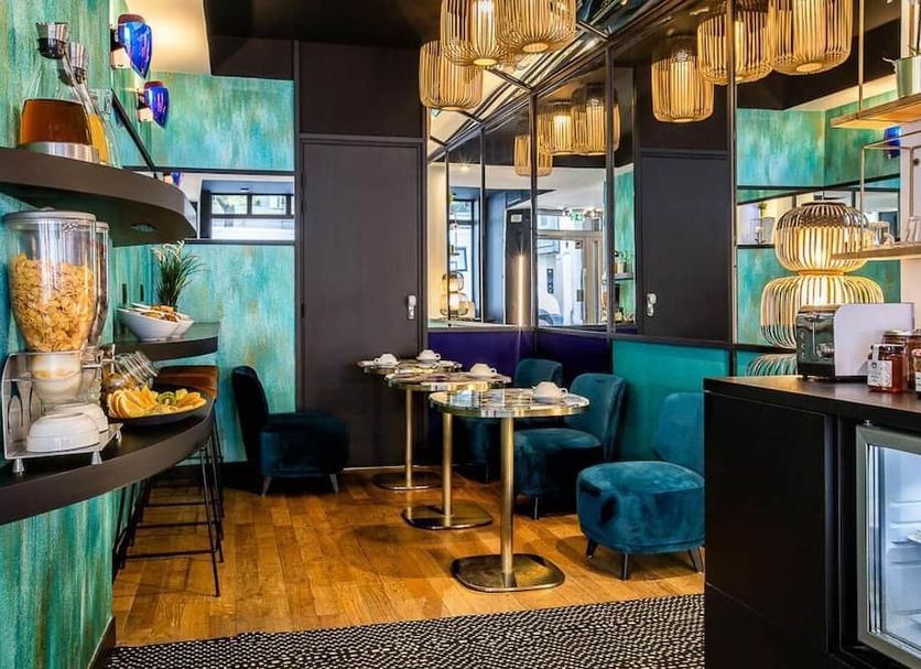 Hotel Pilime in Paris dining area with teal seating, gold pendant lights, and wood floors