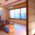 Ito Hotel Ryokufuen tatami guest room with low table, TV, and large window view in Itō