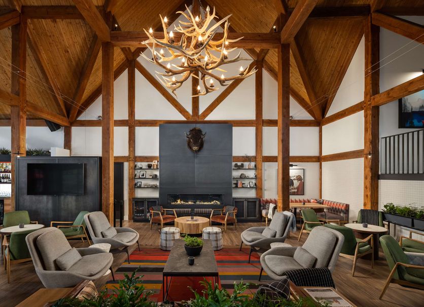 Buffalo Mountain Lodge Banff lobby lounge with wood beams, antler chandelier and fireplace seating