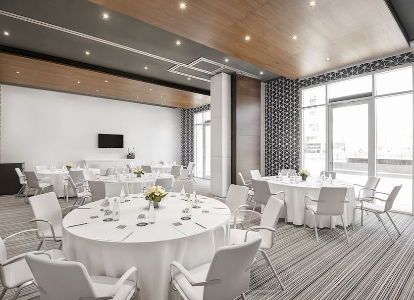 Hyatt Place Dubai Wasl District Residences banquet room with round tables, white chairs, and large windows in Dubai