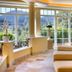 Hotel Bareiss in Baiersbronn lounge with sunlit windows, mountain views, and beige seating with striped pillows