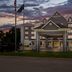 Country Inn & Suites by Radisson Princeton, WV exterior at dusk with covered entrance and flags